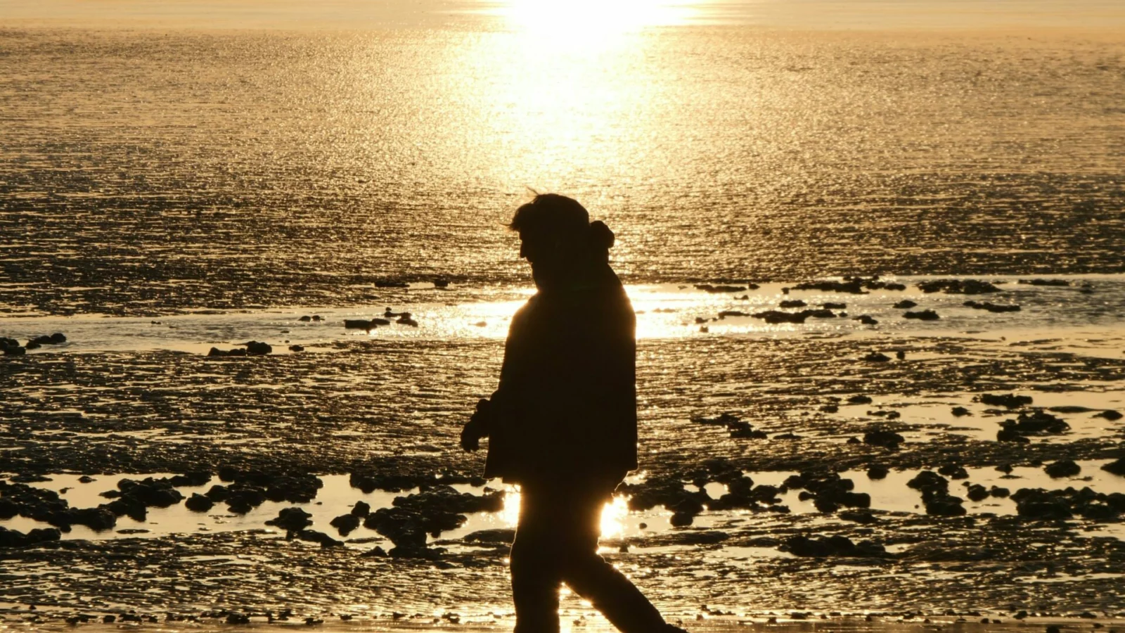 Promeneur sur la plage de Châtelaillon-Plage au soleil couchant