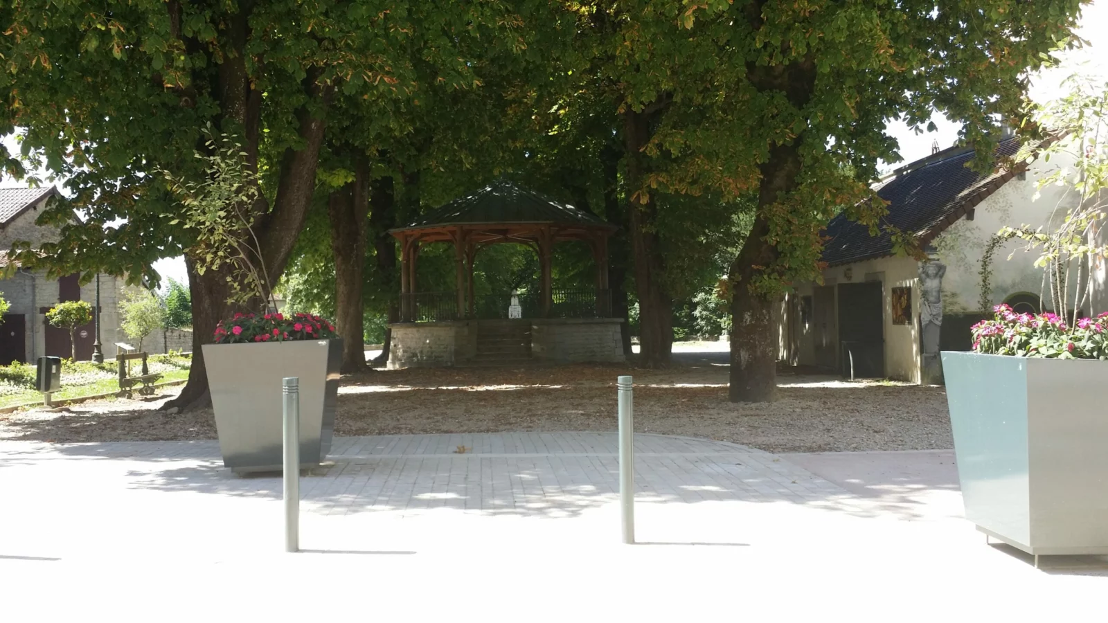 Accompagnement des entreprises Le kiosque à musique et les arbres sur une place de Poligny
