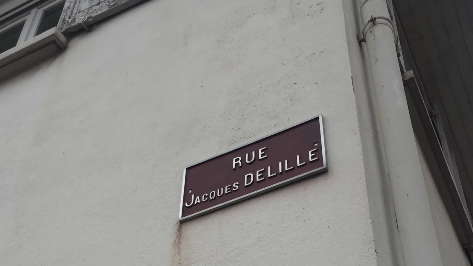 Création et suivi de sites internet Plaque de la rue Jacques-Delille sur une façade à Saint-Dié-des-Vosges